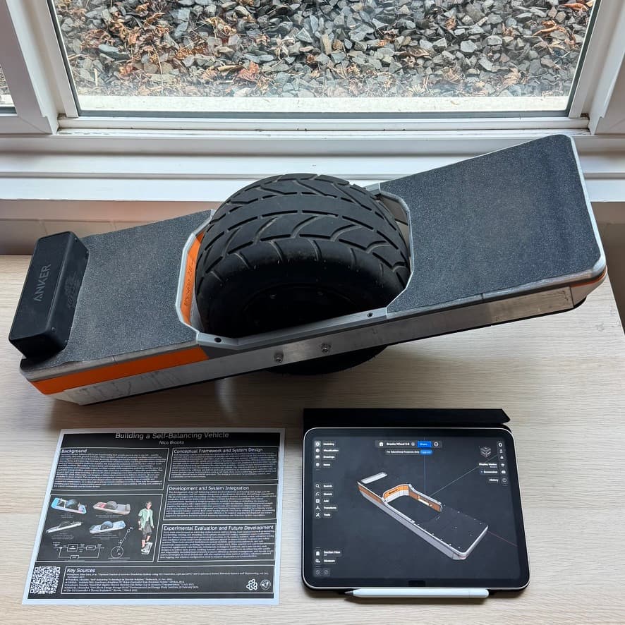 The self-balancing vehicle beside its research poster and a tablet showing the CAD design.